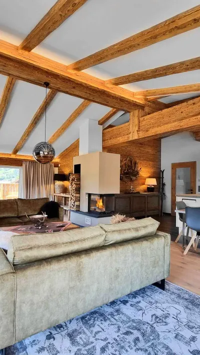 Sandro Anibas sitzt in einer luxuriösen Wohnung und schaut lächelnt von einer Zeitschrift auf