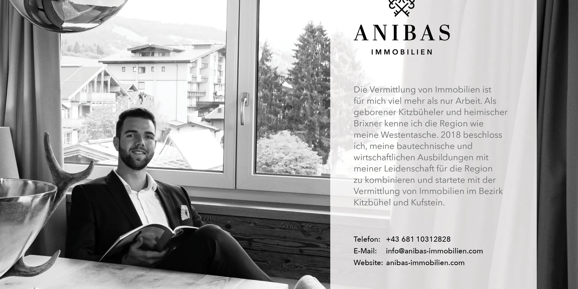 Sandro Anibas sitzt in einer luxuriösen Wohnung und schaut lächelnt von einer Zeitschrift auf