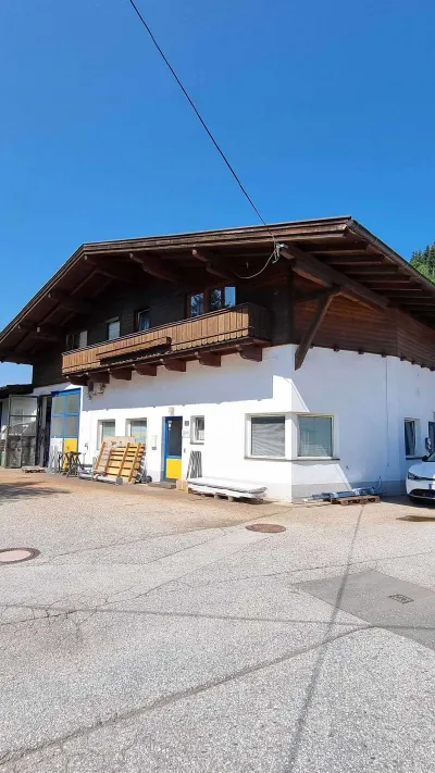 Sandro Anibas sitzt in einer luxuriösen Wohnung und schaut lächelnt von einer Zeitschrift auf