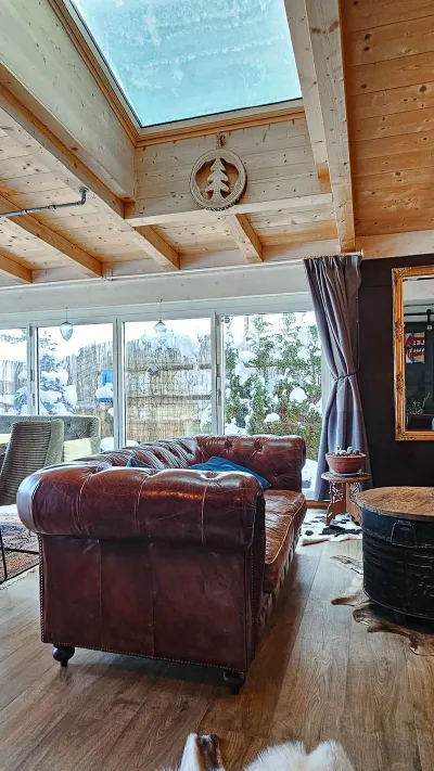 Sandro Anibas sitzt in einer luxuriösen Wohnung und schaut lächelnt von einer Zeitschrift auf