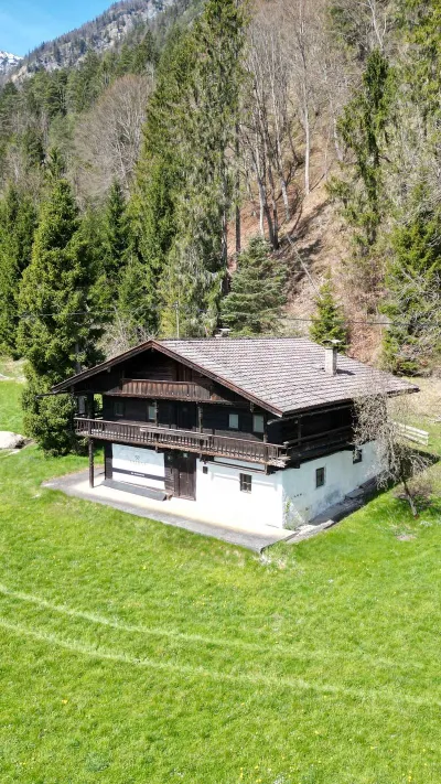 Sandro Anibas sitzt in einer luxuriösen Wohnung und schaut lächelnt von einer Zeitschrift auf