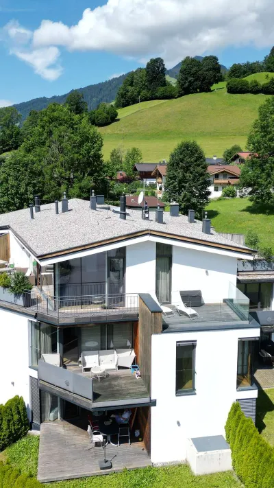 Sandro Anibas sitzt in einer luxuriösen Wohnung und schaut lächelnt von einer Zeitschrift auf
