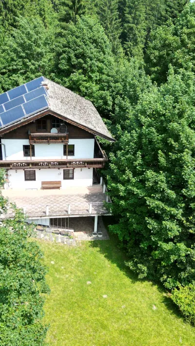 Sandro Anibas sitzt in einer luxuriösen Wohnung und schaut lächelnt von einer Zeitschrift auf