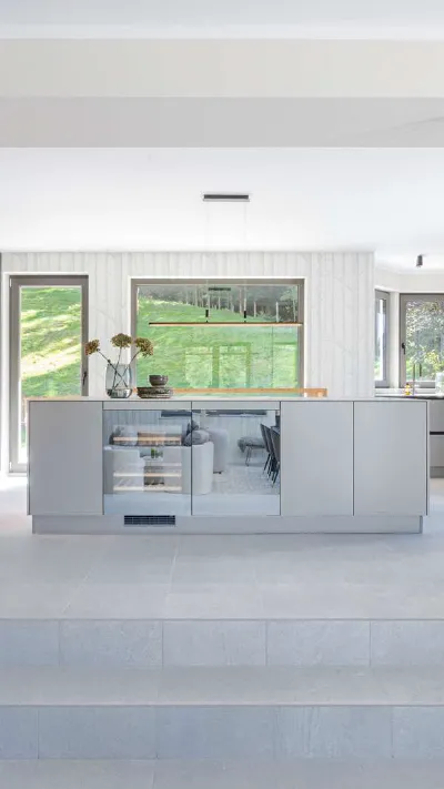 Sandro Anibas sitzt in einer luxuriösen Wohnung und schaut lächelnt von einer Zeitschrift auf