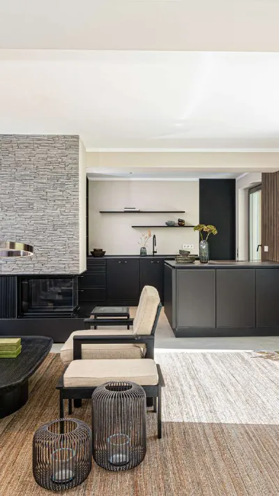 Sandro Anibas sitzt in einer luxuriösen Wohnung und schaut lächelnt von einer Zeitschrift auf