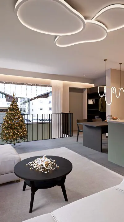 Sandro Anibas sitzt in einer luxuriösen Wohnung und schaut lächelnt von einer Zeitschrift auf