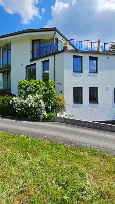 Sandro Anibas sitzt in einer luxuriösen Wohnung und schaut lächelnt von einer Zeitschrift auf