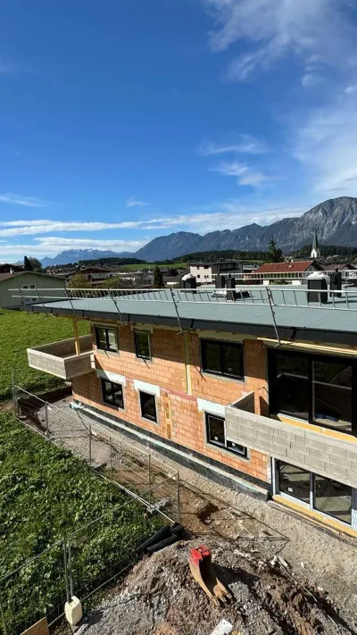 Sandro Anibas sitzt in einer luxuriösen Wohnung und schaut lächelnt von einer Zeitschrift auf