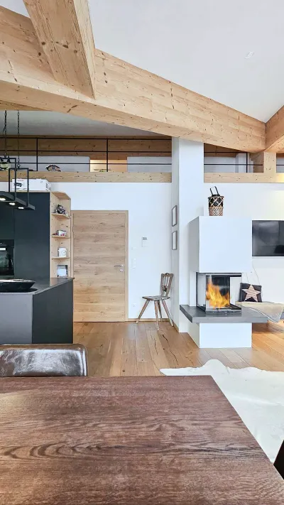 Sandro Anibas sitzt in einer luxuriösen Wohnung und schaut lächelnt von einer Zeitschrift auf