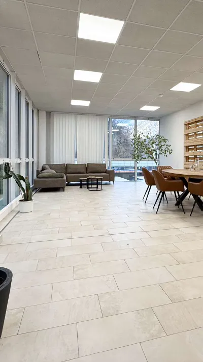 Sandro Anibas sitzt in einer luxuriösen Wohnung und schaut lächelnt von einer Zeitschrift auf