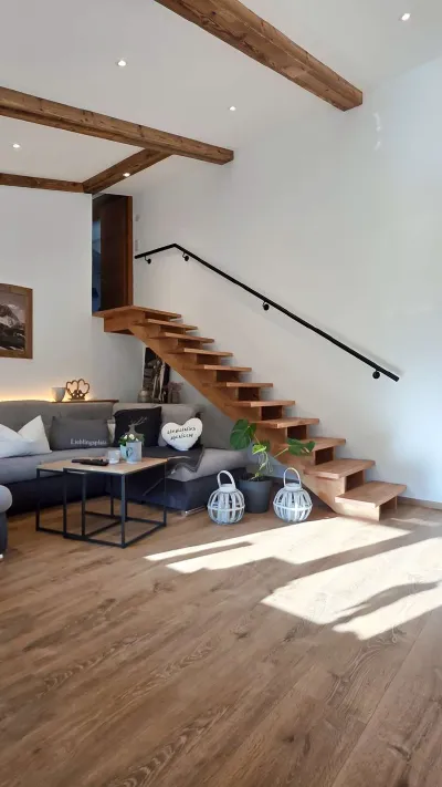 Sandro Anibas sitzt in einer luxuriösen Wohnung und schaut lächelnt von einer Zeitschrift auf