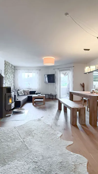 Sandro Anibas sitzt in einer luxuriösen Wohnung und schaut lächelnt von einer Zeitschrift auf