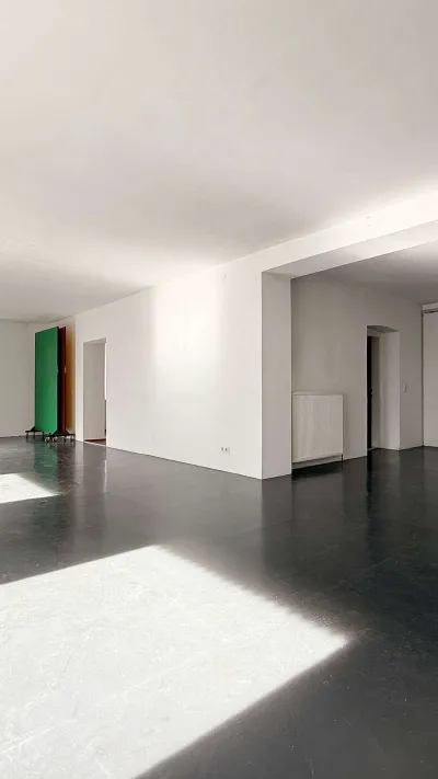 Sandro Anibas sitzt in einer luxuriösen Wohnung und schaut lächelnt von einer Zeitschrift auf