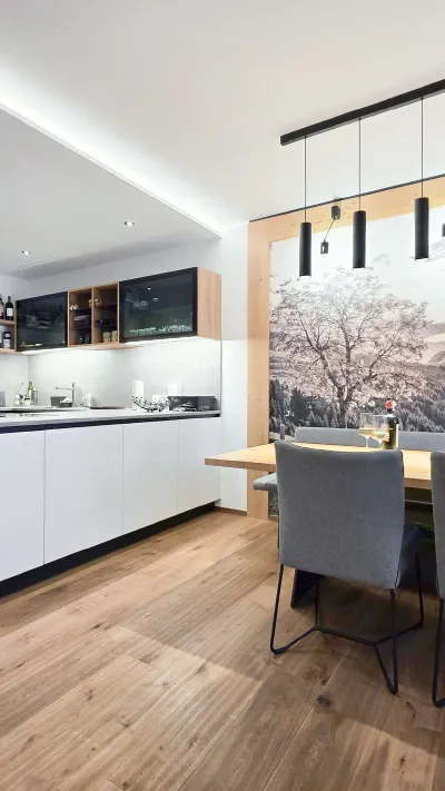 Sandro Anibas sitzt in einer luxuriösen Wohnung und schaut lächelnt von einer Zeitschrift auf