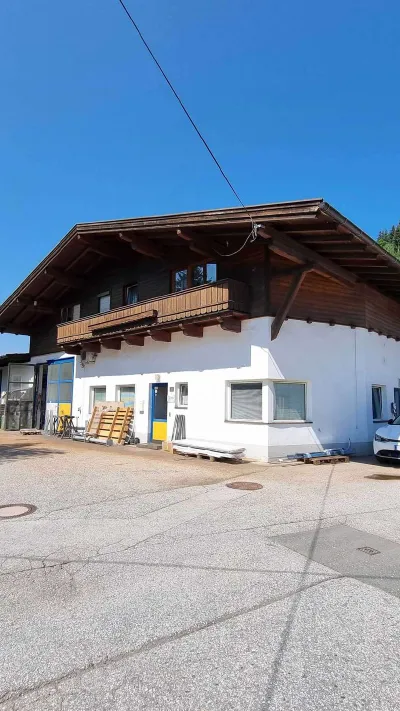 Sandro Anibas sitzt in einer luxuriösen Wohnung und schaut lächelnt von einer Zeitschrift auf