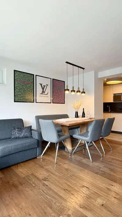 Sandro Anibas sitzt in einer luxuriösen Wohnung und schaut lächelnt von einer Zeitschrift auf
