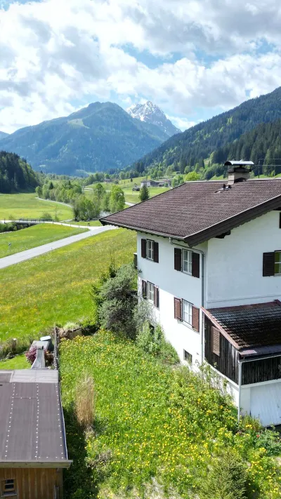 Sandro Anibas sitzt in einer luxuriösen Wohnung und schaut lächelnt von einer Zeitschrift auf