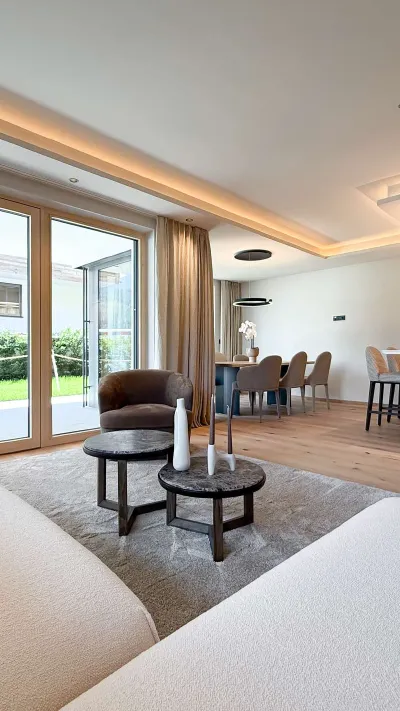 Sandro Anibas sitzt in einer luxuriösen Wohnung und schaut lächelnt von einer Zeitschrift auf