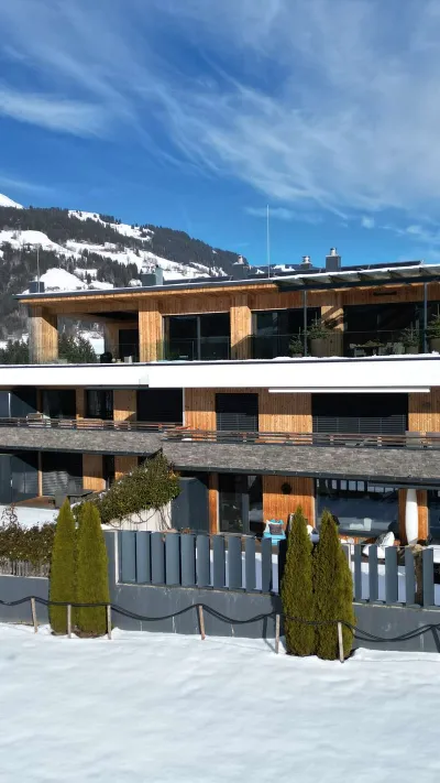 Sandro Anibas sitzt in einer luxuriösen Wohnung und schaut lächelnt von einer Zeitschrift auf