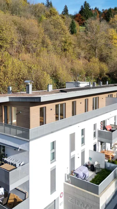 Sandro Anibas sitzt in einer luxuriösen Wohnung und schaut lächelnt von einer Zeitschrift auf