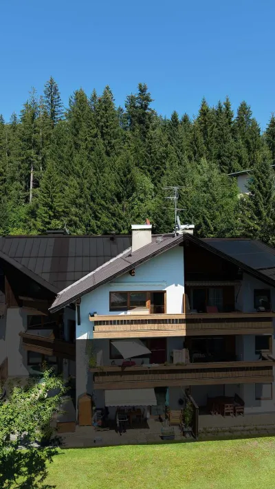 Sandro Anibas sitzt in einer luxuriösen Wohnung und schaut lächelnt von einer Zeitschrift auf