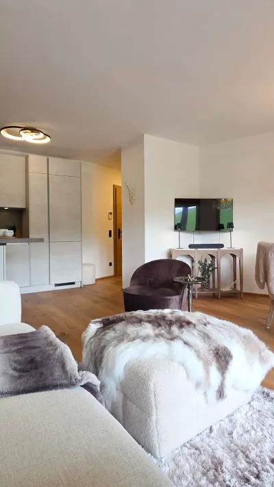 Sandro Anibas sitzt in einer luxuriösen Wohnung und schaut lächelnt von einer Zeitschrift auf