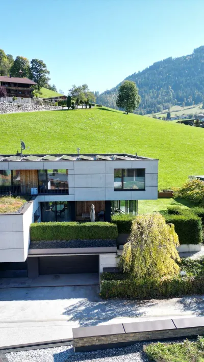 Sandro Anibas sitzt in einer luxuriösen Wohnung und schaut lächelnt von einer Zeitschrift auf