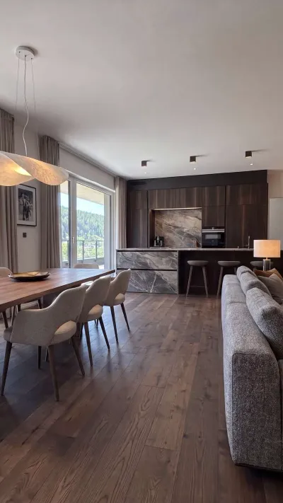 Sandro Anibas sitzt in einer luxuriösen Wohnung und schaut lächelnt von einer Zeitschrift auf